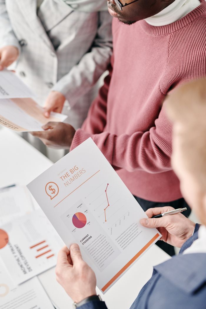 Crafting Captivating Headlines: Your awesome post title goes here A group of professionals reviewing financial reports with graphs and statistics at a meeting.