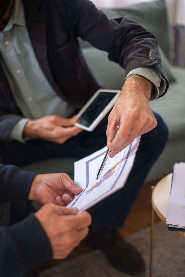 Mastering the First Impression: Your intriguing post title goes here Two professionals in a business meeting discussing documents and a tablet.